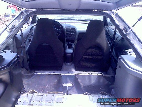 Interior view of a car with front seats and empty rear cargo area. Dashboard and steering wheel visible