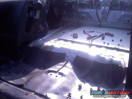 Interior of a car with seats removed and tools on the floor