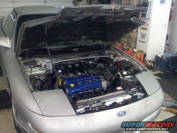 Silver 1993 Ford Probe with hood open, showing a blue engine cover and the front end