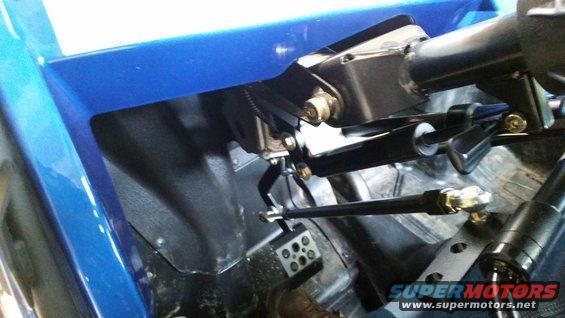 Close-up of UTV interior showing steering column, pedals, and blue body panel