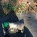 1979 Ford Bronco - A transmission part, partially painted green, lies on the ground next to some foliage.
