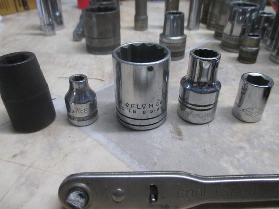 Assortment of socket wrenches and a Craftsman ratchet on a workbench