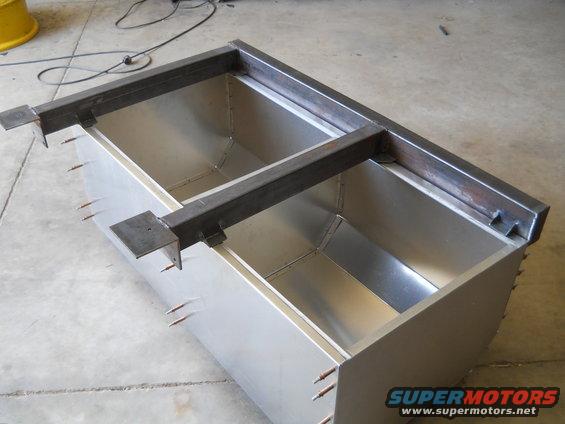 metal tanks with steel frame on top, in a workshop setting