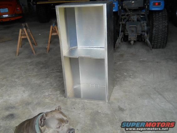 Aluminum cabinet in garage with blue tractor and dog