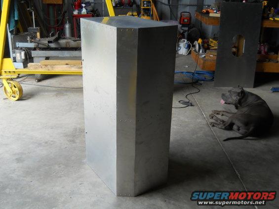 Metal enclosure in a workshop with a dog lying on the floor