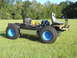 1992 Ford Bronco - This custom-built vehicle chassis features large tires and exposed mechanical components, sitting in a grassy field.