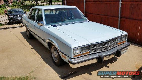 White 1980 Ford Fairmont sedan, 3/4 front view. Grille indicates year