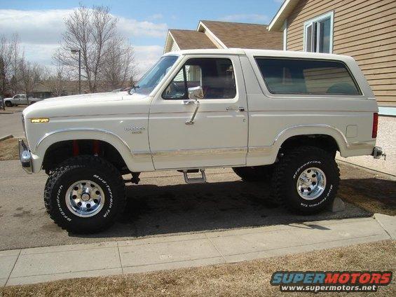 White Ford Bronco with lifted suspension and off-road tires, seen from the side