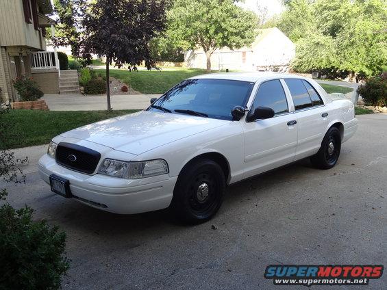 White 2007 Ford Crown Victoria parked on driveway. Black grille, black wheels, tinted windows