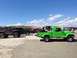 1979 Ford Bronco - Several Jeeps, including a green pickup, are parked on a sandy beach under a blue sky.