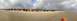 1979 Ford Bronco - Several off-road vehicles are gathered on a wide, sandy beach under a dramatic, cloudy sky.