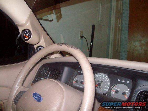 Ford steering wheel, dashboard, and aftermarket gauges mounted on the A-pillar