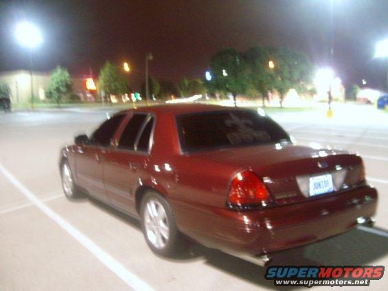 Red Ford Crown Victoria parked at night. License plate says JUNIOR