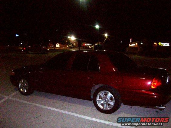 Red 2004 Ford Crown Victoria parked at night, side view