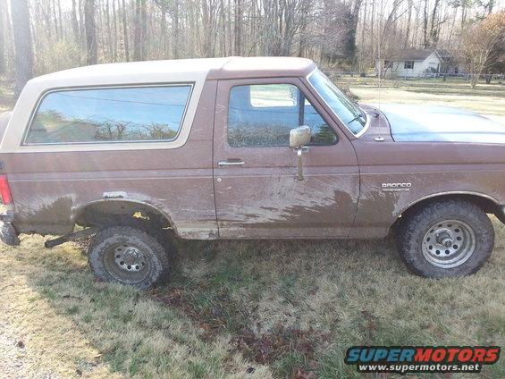 Brown 1991 Ford Bronco side view. Mud splattered