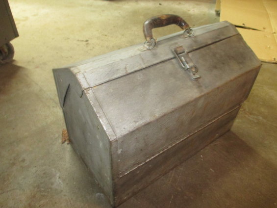 Metal toolbox with a worn leather handle and metal latch