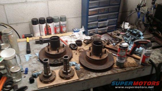 Two brake rotors with hubs and spindles on a workbench