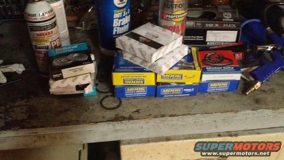 Boxes of Moog and National bearings, brake fluid, and spray cans on a workbench