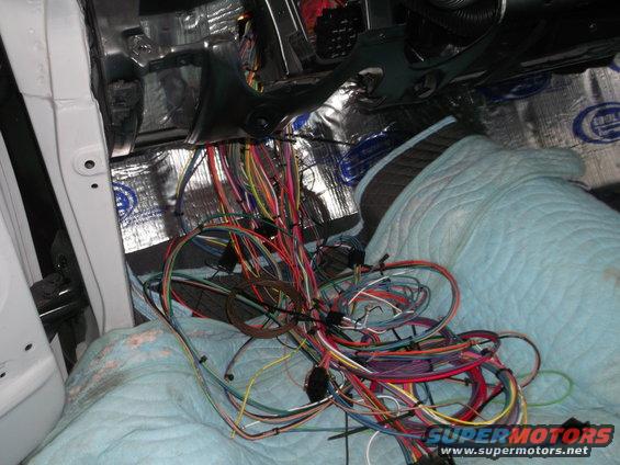 Vehicle interior with a tangled mess of colorful wires and sound deadening material