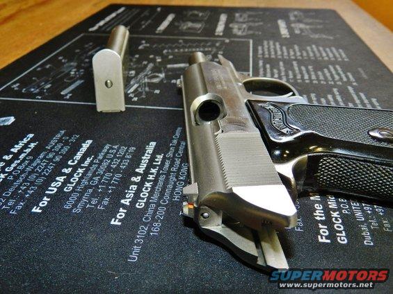 Pistol disassembled with magazine on a gun cleaning mat with Glock contact information