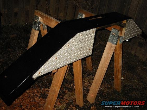 Black custom winch bumper with diamond plate sides on sawhorses