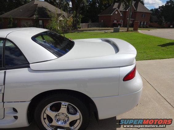 White 1995 Mitsubishi 3000GT parked on a driveway, showing the rear quarter panel and spoiler