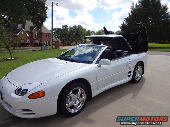 White 1995 Mitsubishi 3000GT convertible with top and hood open, parked on a driveway