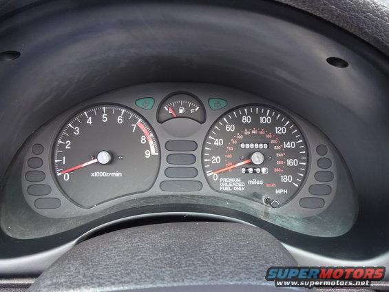 Dashboard gauges for a 1995 Mitsubishi 3000GT, showing tachometer, speedometer, fuel gauge, and odometer