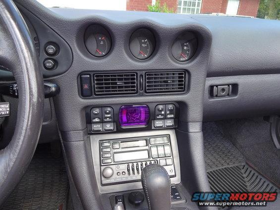 Interior dashboard of a 1995 Mitsubishi 3000GT with purple climate control display