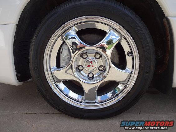 Close-up of a chrome wheel and a silver brake caliper with 'MITSUBISHI' written on it