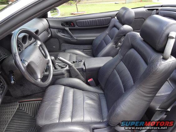 Interior view of black leather seats and dashboard of a convertible sports car
