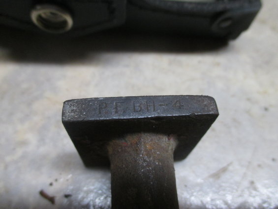 Close-up of a metal stamp with the letters P F B H and the number 4 etched into it