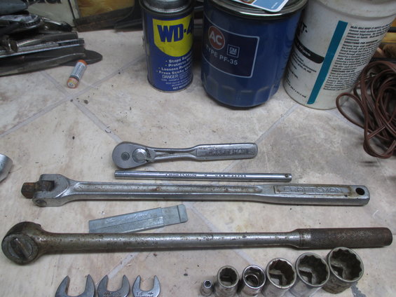 Assorted Craftsman wrenches and sockets with a can of WD-40 and an oil filter