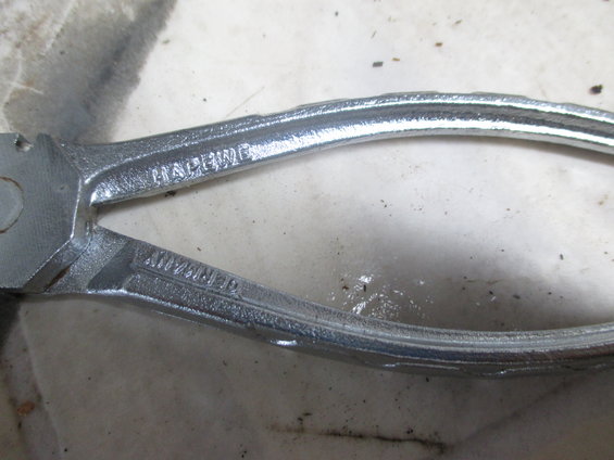 Close-up of pliers with "HAPENED" and "GERMANY" stamped on them