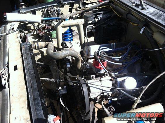 Engine bay with V8 engine, radiator, and various hoses and wires