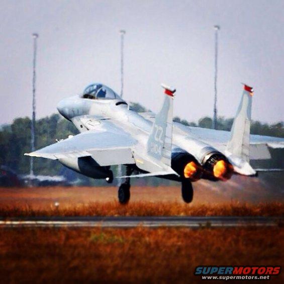Fighter jet with engines on fire, lifting off a runway