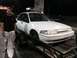 1993 Mercury Tracer - A white 1993 Mercury Tracer is loaded onto a trailer at night, with a man standing beside it.