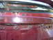 1993 Mazda MX-3 - The rear of a red car shows some rust and exposed wiring, with the word 'unos' visible.