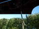 1993 Mazda MX-3 - Wiring harness components are visible under the hood of a vehicle, with a clear sky and trees in the background.