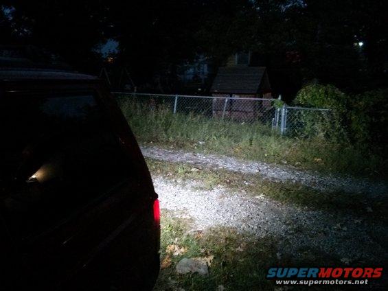 back of a dark SUV parked on a gravel driveway at night