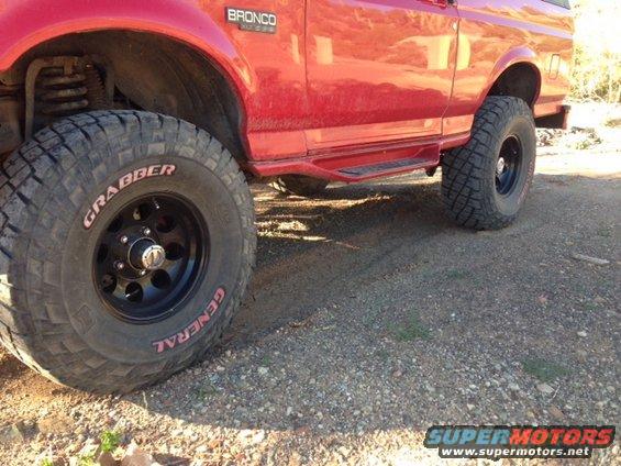 Red 1996 Ford Bronco side view showing off-road tires and running boards