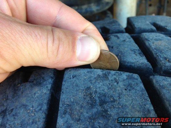 Penny inserted into tire tread to check depth