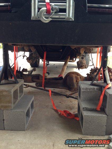 1996 Ford Bronco rear axle and suspension supported by jack stands and cinder blocks during repair
