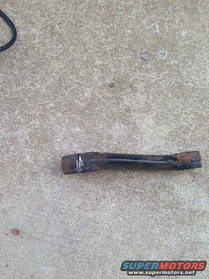 rusted metal bar with white marks on concrete