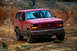 1995 Ford Bronco - This red 1995 Ford Bronco navigates a muddy, off-road course.