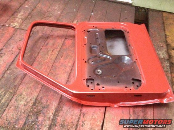 Red truck door, interior side visible, on wooden surface