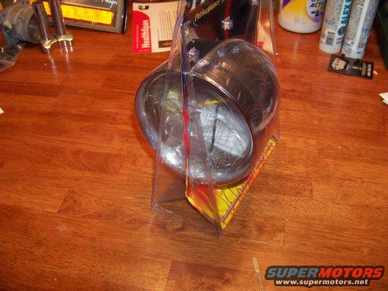 Headlight in plastic packaging on a wooden floor
