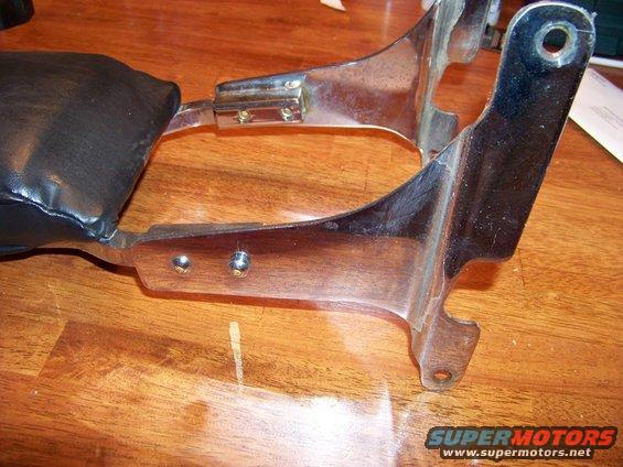 Chrome bracket with black padded backrest, mounted on wooden surface