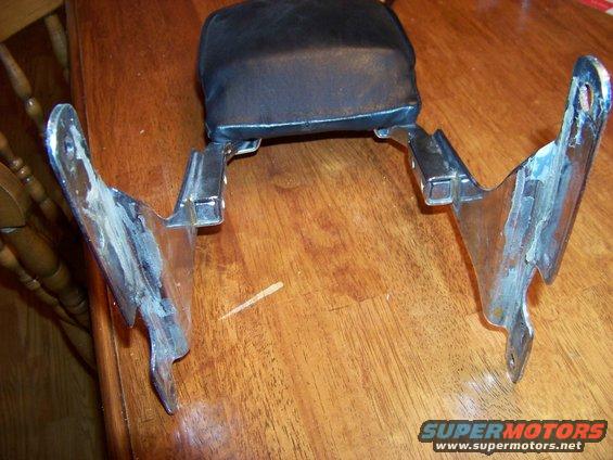 motorcycle backrest with chrome mounting brackets on a wooden table