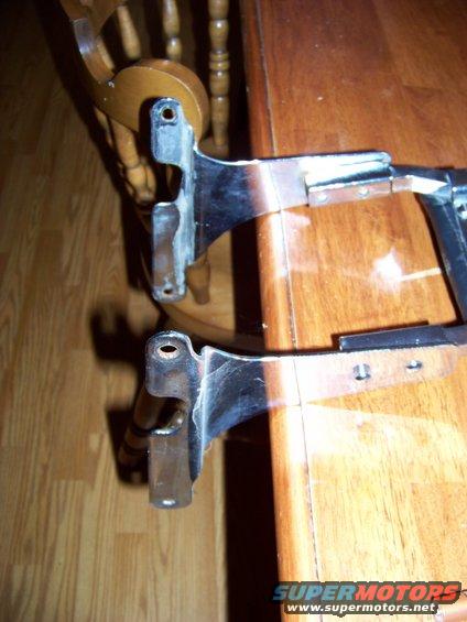 two chrome car parts on a wooden table